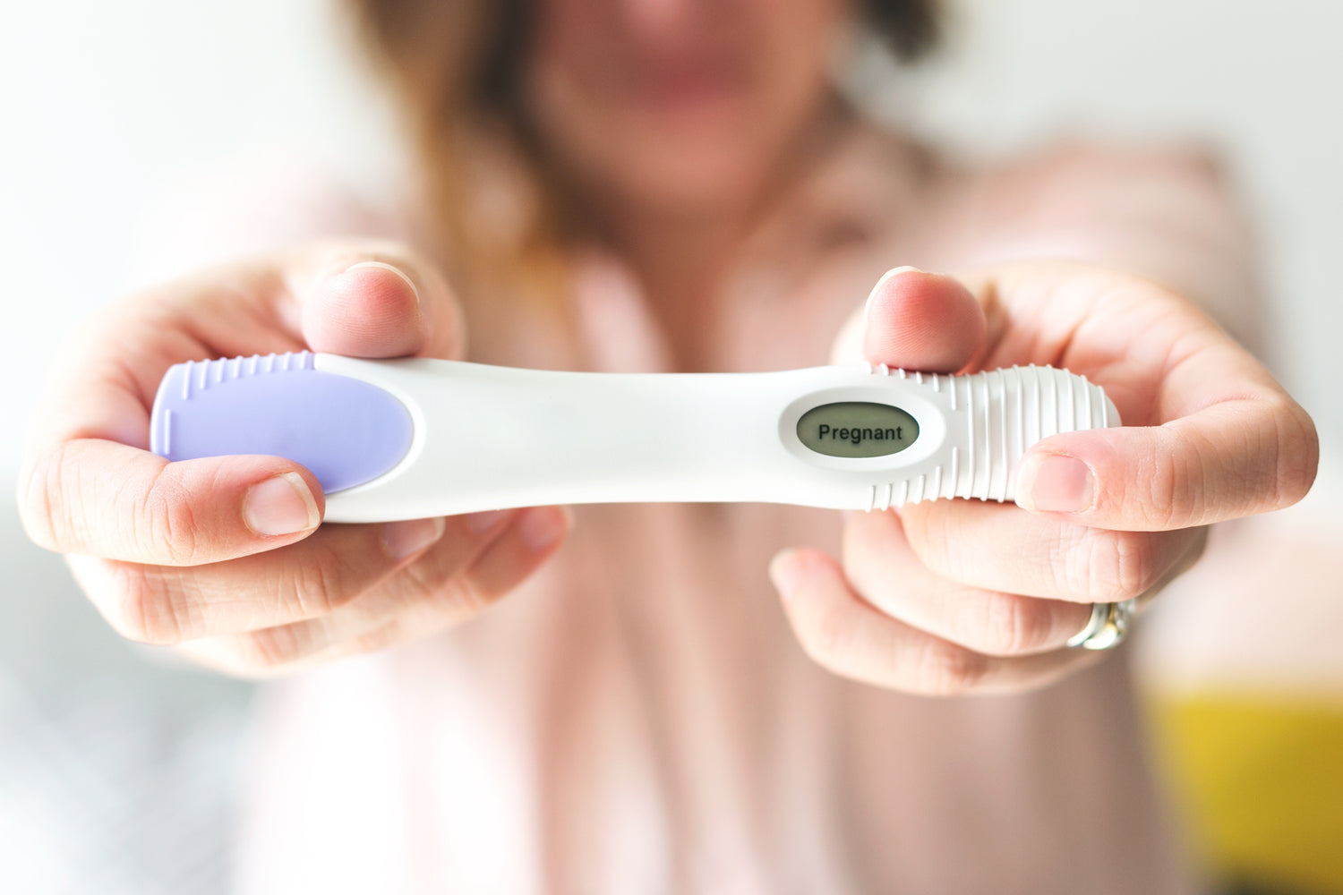 woman holding positive pregnancy test